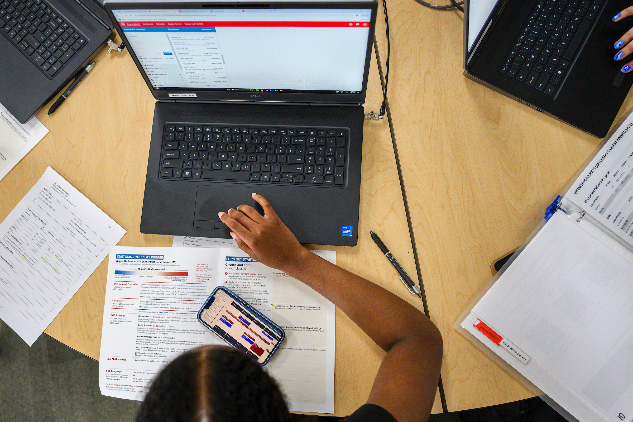 A student works on their semester schedule on a laptop, utilizing the Course Search & Enroll tool.