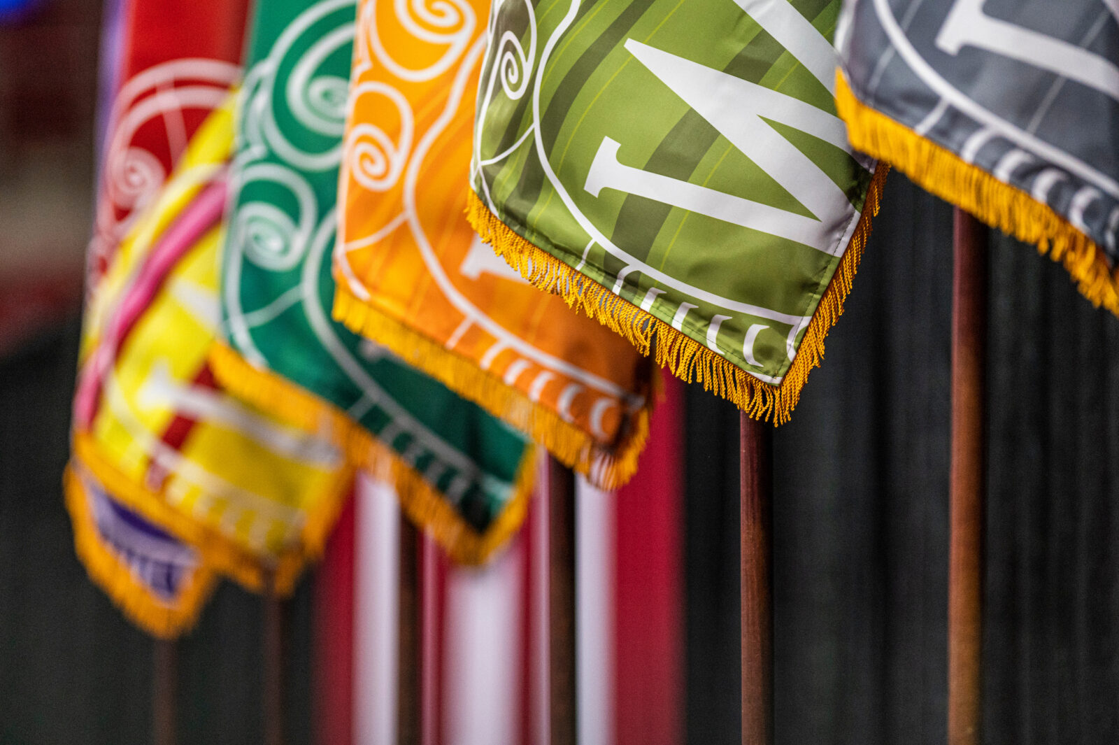 Flags representing UW-Madison's different schools and colleges line the Kohl Center stage at Convocation.