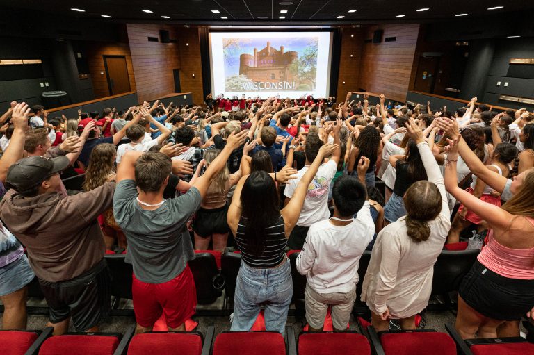 Students with arms raised during UW Orientation programming